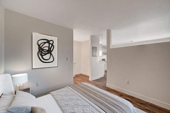 A bedroom with a large bed and a painting on the wall.