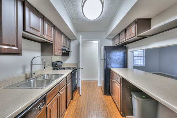 A kitchen with brown cabinets and a white sink at Landmark at Lyncrest Reserve Apartments, Nashville, TN