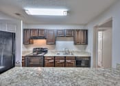 Thumbnail 9 of 28 - A kitchen with granite countertops and stainless steel appliances at Landmark at Lyncrest Reserve Apartments, Nashville, TN, 37209