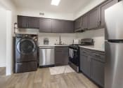 Thumbnail 3 of 9 - a kitchen with stainless steel appliances and a washer and dryer at Copper and Quarry Village, Pikesville, MD, 21209