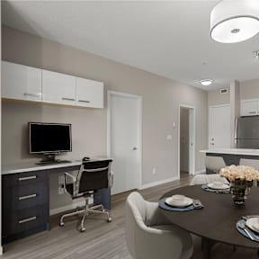 a dining room and kitchen with a table and chairs and a tv