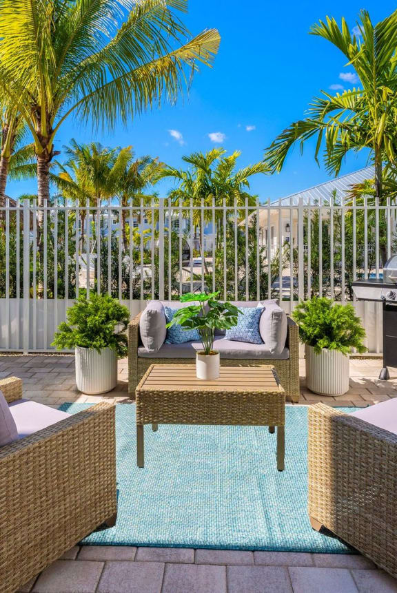a patio with chairs and a table and a grill