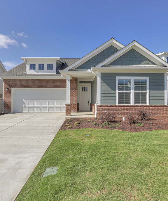 A house with a grey front yard and a white garage door.