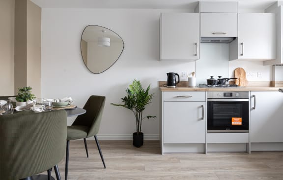 a kitchen with white cabinets and a table and chairs