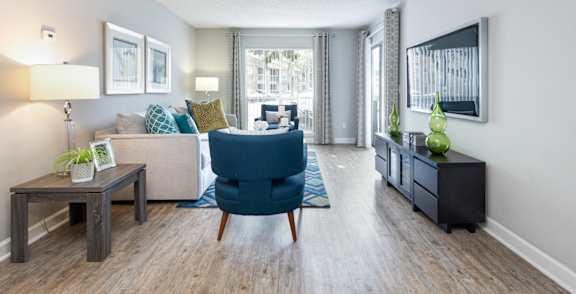 A living room with a blue chair and a grey couch.