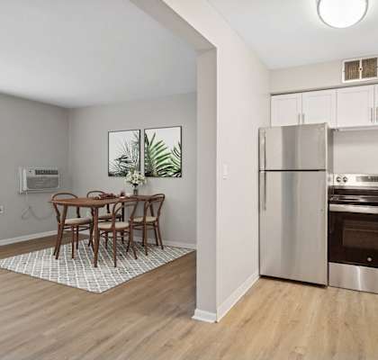 A kitchen with a dining table and chairs in the middle of the room.