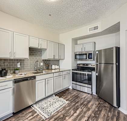 A kitchen with white cabinets and stainless steel appliances.