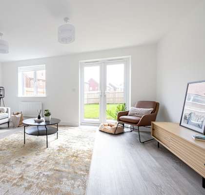 a living room with white couches and chairs and a tv