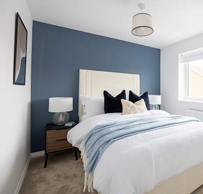 a bedroom with a bed and a blue wall and a window