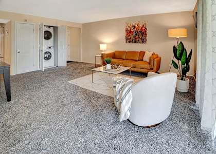 a living room with a couch coffee table and a washer and dryer, Kenilworth at Charles Apartments, Towson, MD