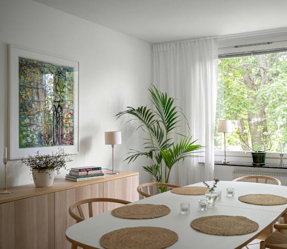 A dining room with a white table and chairs.