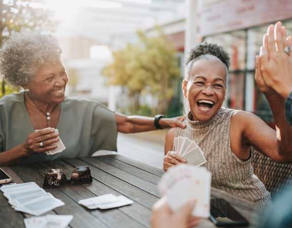 A group of people are sitting around a table, laughing and enjoying each other's company.
