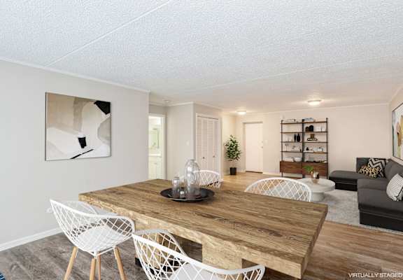 A living room with a wooden table and white chairs.