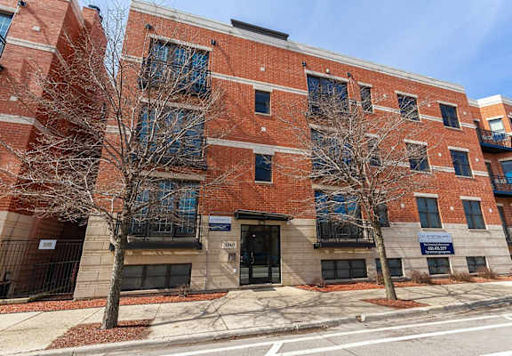 a brick building with two trees in front of it