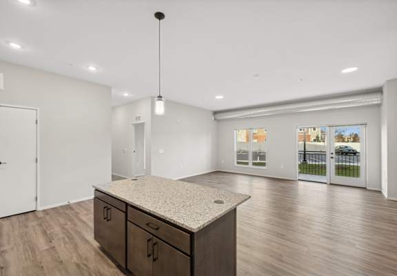 A kitchen with a granite countertop and wooden flooring.