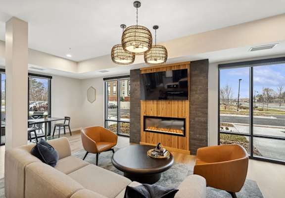 A modern living room with a fireplace and a large window.