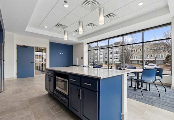 A kitchen with blue cabinets and a large island.