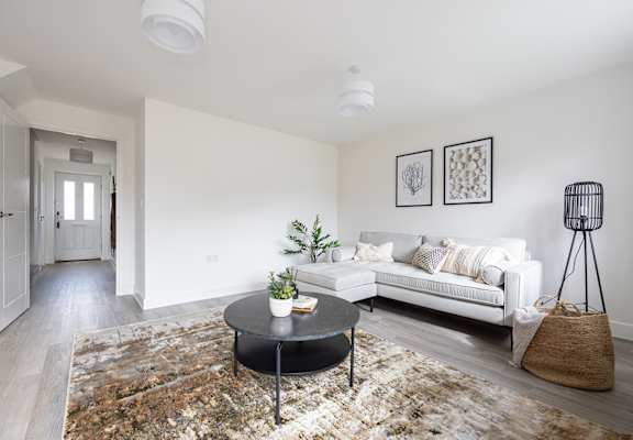 a living room with a couch and a coffee table    and a hallway