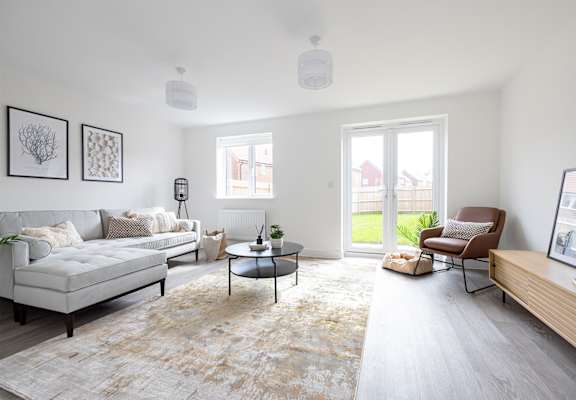 a living room with white couches and chairs and a tv