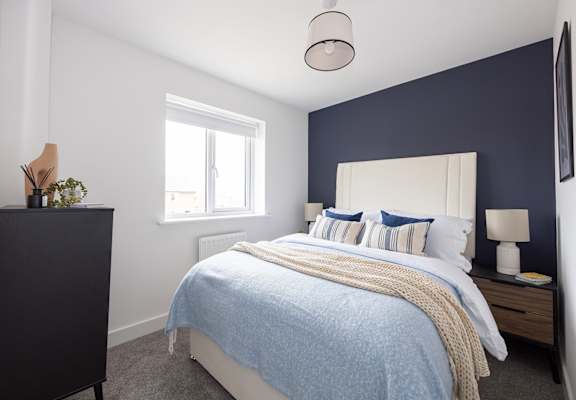 a blue and white bedroom with a bed and a window