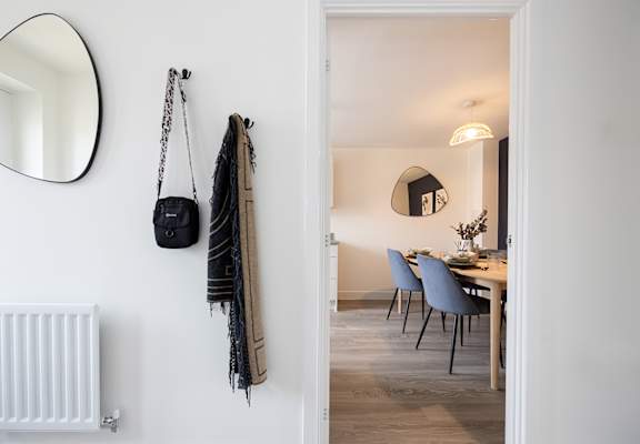 a living room and dining room with a table and chairs and a mirror