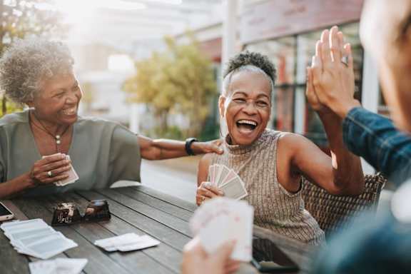 A group of people are sitting around a table, laughing and enjoying each other's company.