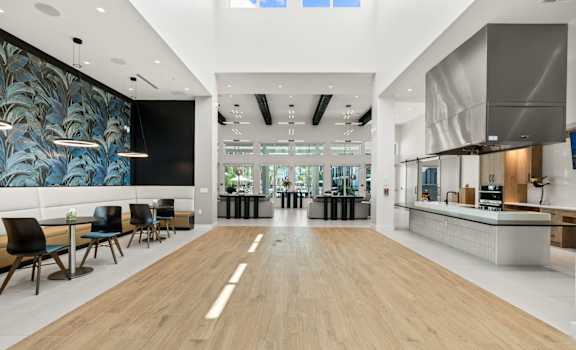 a large room with a kitchen and a table with chairs at Mira at Palmer Ranch in Sarasota, FL