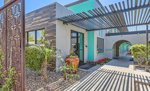the entrance to a house with a sidewalk and plants