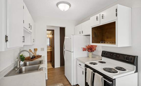 a kitchen with white cabinets and a stove and a sink