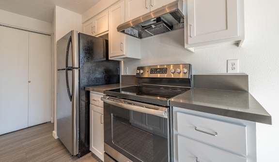 a kitchen with white cabinets and stainless steel appliances