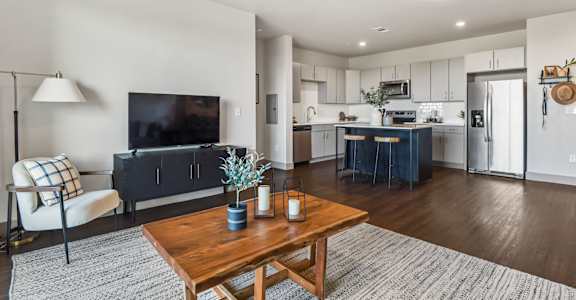 A modern living room with a wooden coffee table and a flat screen TV.