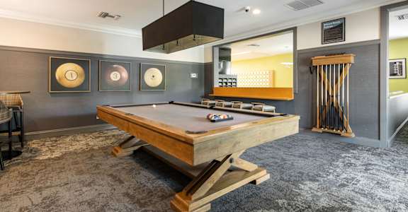A pool table in a room with a grey carpet.