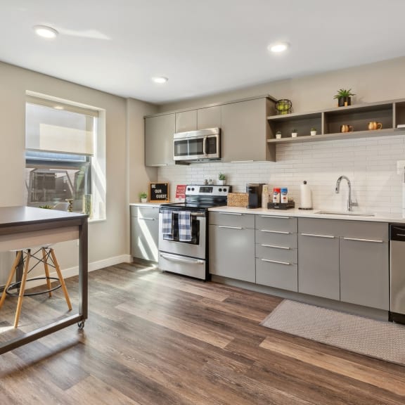 a kitchen with white cabinets and stainless steel appliances