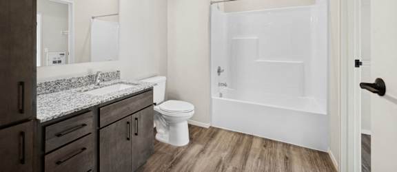 A bathroom with a toilet, sink, and shower.