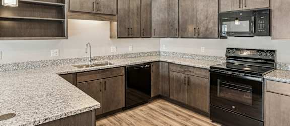A kitchen with wooden cabinets and a granite countertop.