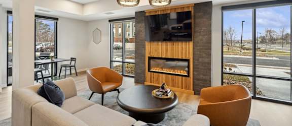 A modern living room with a fireplace and a large window.