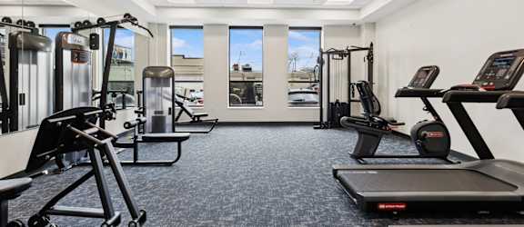 A gym with treadmills, elliptical machines, and other exercise equipment.