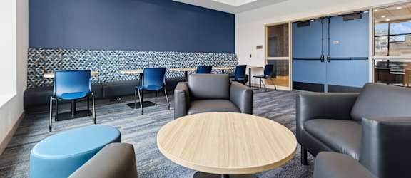 A room with blue chairs and a wooden table.