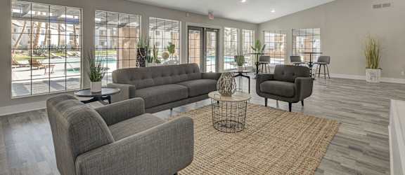 A living room with grey couches and a large window.