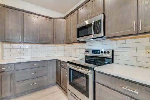 a kitchen with gray cabinets and white tile