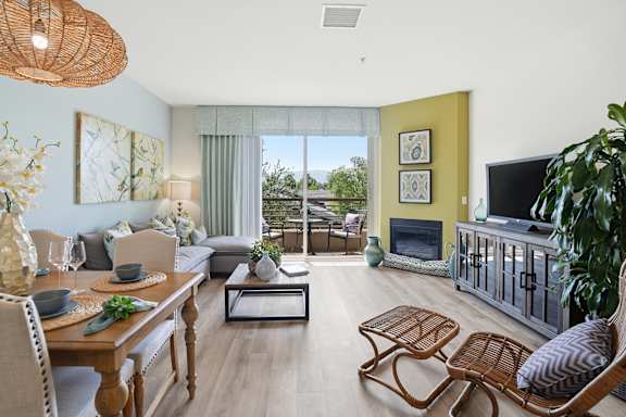 a living room with a gray couch and a glass table