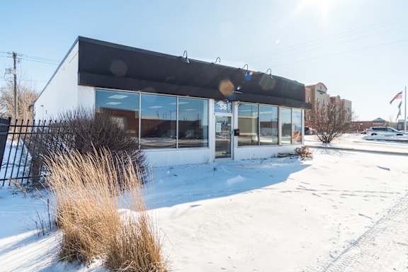 A building with a black awning and a sign that reads "38" is surrounded by snow.