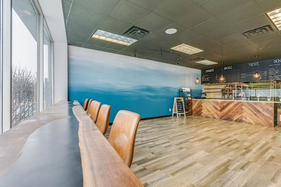A long wooden table is in a room with a blue painted wall.