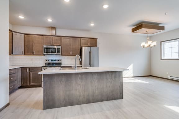 a kitchen with a large center island with a sink and a chrome faucet