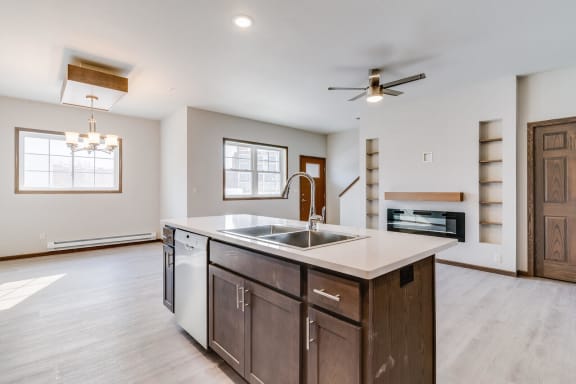 a kitchen with a large center island with a sink and a ceiling fan