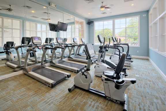 A gym with treadmills and elliptical machines.
