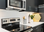 Thumbnail 7 of 9 - a kitchen with a stove and a microwave at The Hendry, Henderson, 89074