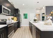 Thumbnail 9 of 9 - an open kitchen with stainless steel appliances and white countertops at The Hendry, Henderson, 89074