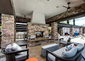 Thumbnail 44 of 62 - Outdoor fireplace with seating at The Grove Apartments, Ontario, CA