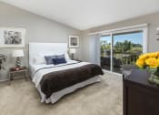 Thumbnail 19 of 28 - Two-Bedroom Apartments in Dana Pointe, CA - Harbor Pointe - Bedroom with Balcony Access, Carpeting, and Nightstands at Harbor Pointe, Dana Point, CA